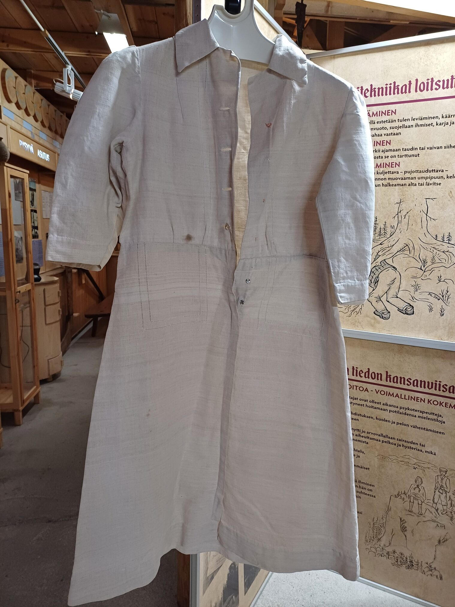 Pellavamekko henkarissa Konneveden museolla, taustalla perinnetauluja ja museon esineistöä